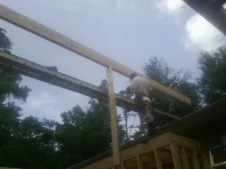 Carpenter setting a ridge beam over a new addition frame — Ice Dam Removal by Roofing Brothers in Lockbourne