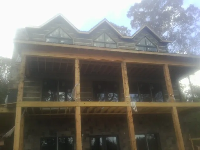 Dormers and porch framing on a large log home under construction — Roof Coating work by our crew in Lockbourne