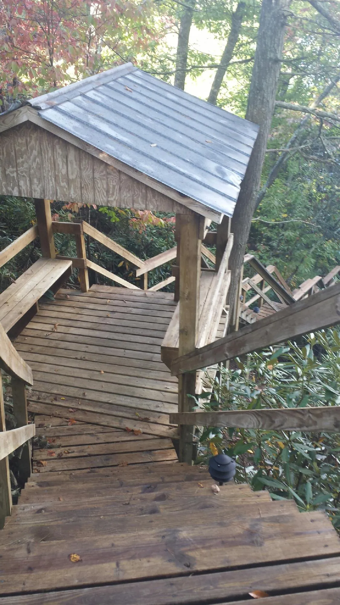 Metal roofed shelter over wooden steps on a wooded walkway — Skylight Repair & Installation work by our crew in Lockbourne