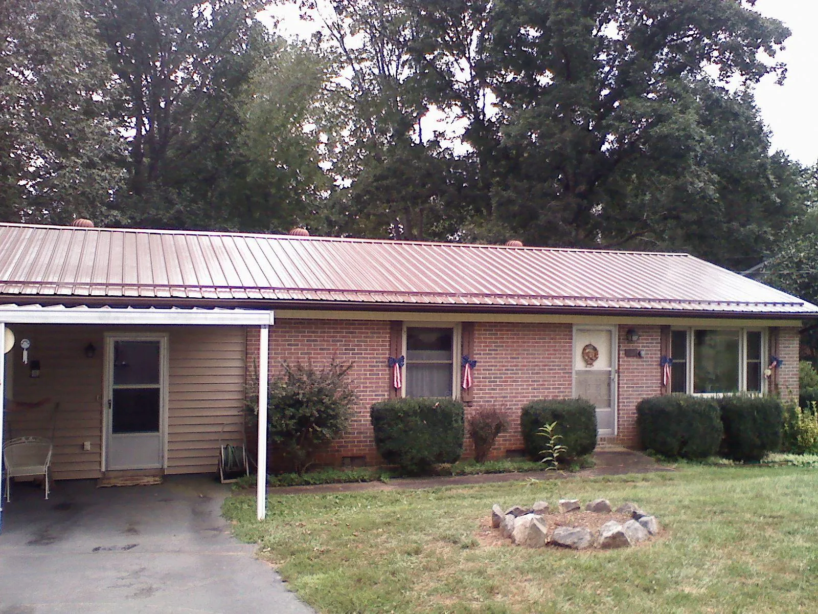 Bronze metal roof and carport on a brick ranch home — Roof Repair work by our crew in Lockbourne